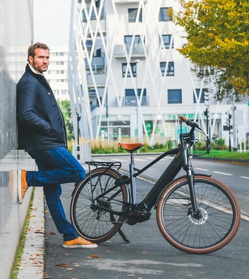 Un homme à côté d'un vélo électrique O2feel e-bikes